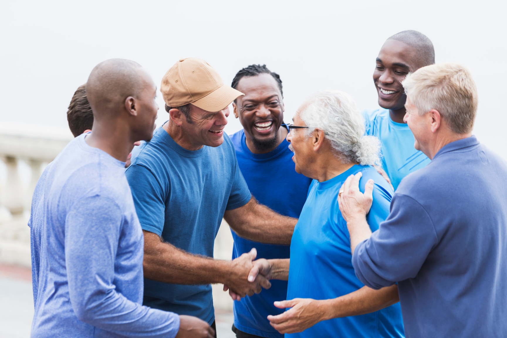 Multi-racial group of men, shaking hands